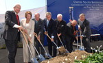 Speakers at the USIP groundbreaking ceremony perform a ceremonial shovel-turning.
