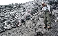 Geologist stands by moving lava on steep Pulama pali, Kilauea volcano, Hawai`i