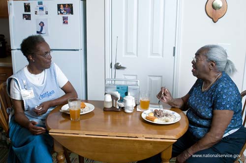 On April 1, 2008, Senior Companion Euphina Irvin eats breakfast with client Costella Black in her home in North Charleston, South Carolina.