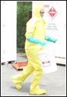 woman in hazardous waste suite moving materials