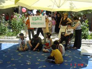Anar (in wheelchair) participates in a role play activity at the opening ceremony for the USAID-supported Children and Family Support Center in Mingechevir.