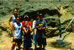 Children next to a hand pump water well