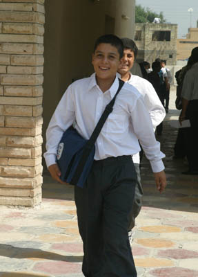 A student from the Zein Al Abdeen secondary boy's school in the Amil district of Baghdad leaves school after classes with his new school bag which contains, pens, pencils, notebooks, a calculator and other school supplies. USAID is funding the purchase and distribution of 1.5 million of the bags through a contract with Creative Associates International. All Iraqi secondary students will receive the bags.