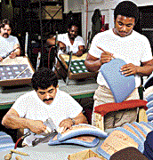 Men applying fabric to furniture parts