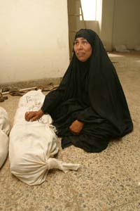 Aweda Abed Al-Amer, 48, grieves over two members of her family found in a mass grave in Musayib, 75 KM SW of Baghdad. She lost 5 members of her family including her husband, son and 3 nephews after an uprising against the Iraqi government in 1991.The bodies wrapped in linen shrouds are being held in a makeshift morgue in a youth center for possible identification.