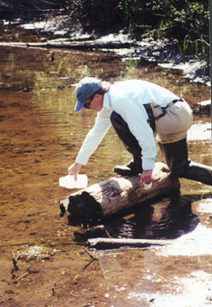 Photo showing Don Campbell collecting a water sample.