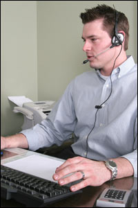 Photo of a man on the phone at a computer