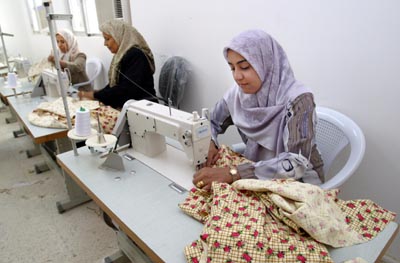 Iraqi women producing garments for the local market at the Fatima Al-Zahra Center for Women's Rights in Hilla, one hour south of Baghdad. The women's center was named by the community after Fatima Al-Zahra, who was the daughter of the Prophet Mohammed. The center is open to all and offers nutrition and health classes, internet/computer training, and sewing facilities.  The center well generate income through sewing production, a planned food catering business, and an internet cafe.  The CPA and USAID/OTI worked with women from across Babil Provence to establish the center. It is the first of five such centers to open in the south central region of Iraq.