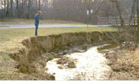 image of person standing over eroded stream