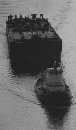 image of tugboat pulling barge