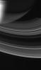 The rings of Saturn glow softly as sunlight from below wends its way through. Some of the Sun's light bounces off the rings' opposite side