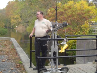 A USGS employee explains stream-gaging equipment to the WZBN television crew.