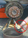 Photo showing brake dust being blown away using compressed air.  This practice is strongly discouraged