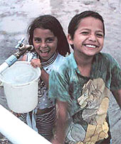 Photo of children receiving clean water from a safe source.