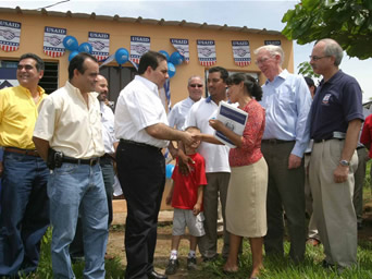 Photo ofEl Salvador   President Elias Antonio Saca (3rd left) gives a house ownership title to a   beneficiary of USAID’s Earthquake Recovery Program (ERP), during the program   close out ceremony held in La Nueva Cruzadilla de San   Juan, in Jiquilisco,   Usulutan, on July 20,   2005.  U.S. Ambassador   Douglas Barclay (2nd right) and USAID Director Mark Silverman (right) attended   the ceremony.