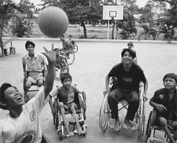 Photo: Young boys in wheelchairs play basketball.