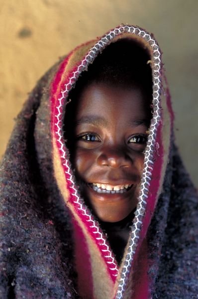 Young girls enjoying a moment of warmth from a blanket donated by one of the USAID Zambia partner program. Photo: Jon Warren/World Vision