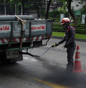 Photo of an officer with Thailand's Pollution Control Department testing a truck's tailpipe emissions.