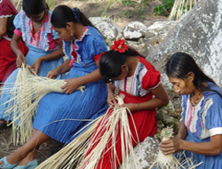 Photo of women weaving bottle sleeves.