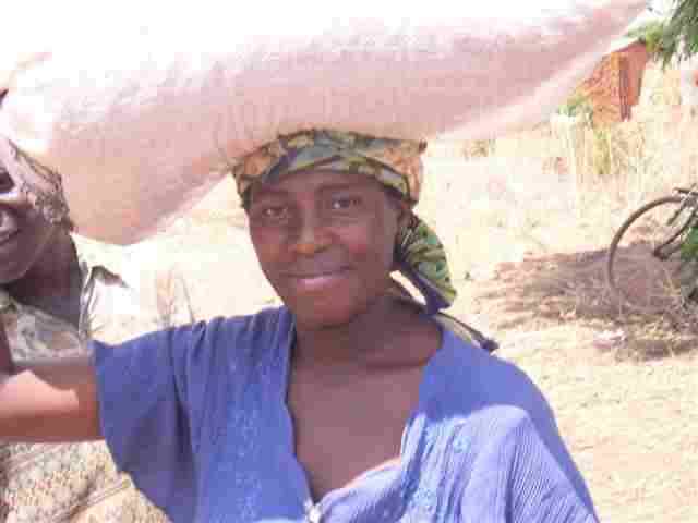 Woman carrying grain on her head (Photo by: Ephraim Mazizwa and Gift Livata, Opportunity International Bank of Malawi )