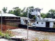 Photo showing barges going past site of dispersed barrier on Chicago Ship and Sanitary Canal