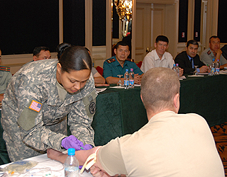 The American trainers demonstrate how to collect a blood sample