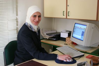 Photo of entrepreneur Sreen Abu Saif sitting at her computer. This Jordanian woman runs a small web design and hosting business in Amman, Jordan