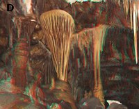 Large, round, shield-like cavern formations (stalagmites) in a cavernous passage