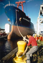 Man tying a large freighter to the dock