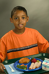 Student holds a tray displaying a healthy school meal: Click here for full photo caption.