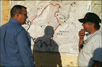 Photo | Senator Tester looks over a map at the Black Cat Fire camp