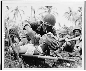 Photo: Navy corpsman gives drink to wounded marine on Guam
