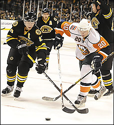 Even with two sticks, Sean Bergenheim, right, and the Islanders couldn't keep up with P.J. Axelsson, left, and the surging Bruins on Friday afternoon in Boston.