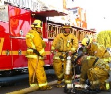 Firefighters move equipment from fire truck.