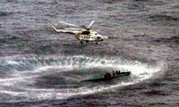 Helicopter hovers above a self-propelled semi-submersible vessel.