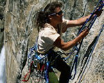 Photo of a person climbing to the top of a rock peak
