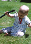 Baby playing with water hose.