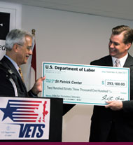 A Federal governement representative presents a check to a community-based organization representing the Federal grant for which they successfully competed