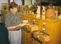 Photo of FPL employee looking at wood samples in the Center for Wood Anatomy archives.