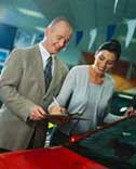 A woman signing paperwork for her new car.