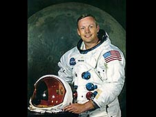 Armstrong in a white spacesuit in front of a picture of the moon