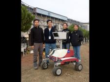 From left to right: NASA Ames' robot software engineer, Vinh To; lead of the Intelligent Robotics Group, Terry Fong; robot hardware engineer, Susan Lee; and robot electrical engineer, Linda Kobayashi, stand beside the K10 Red planetary rover in the Marscape at NASA Ames.