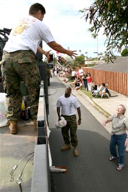 Elaine Masaki tosses a bag of toys to Sgt Jose Godinez of 4th Force Reconnaissance Company during the Hawaii Kai Christmas Parade Nov. 29. The Marines collected toys along the route and at the Koko Marina Shopping Center in support of the Toys for Tots campaign. This year's goal is 40,000 toys. Anyone interested in donating can visit www.toysfortots.org.