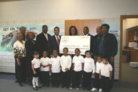 Congressman Jackson with Harvey School District 152 Superintendent Lela Bridges, Mayor Eric Kellogg, State Representative Will Davis, school personnel, and eight young students, displaying a check to the school district for $191,593