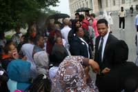 Congressman Jackson speaking with students in the rain, by the Capitol Building