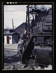 Women wipers of the Chicago and North Western Railroad cleaning one of the giant H class locomotives