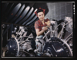 Woman working on an airplane motor at North American Aviation Inc. plant in Calif.