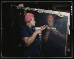 Woman operating a hand drill, working on a Vengeance dive bomber at Vultee-Nashville