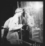 A woman riveter at the Boeing plant in Seattle attaches a sheet of the gleaming outer covering of a fuselage section for a new B-17 F (Flying Fortress) bomber