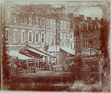 Early 19th century awnings featured canvas coverings stretched between the building facade and post-supported front bars.  Projecting frameworks of extension bars were not common until later in the century.  Photo: Second Street, Philadelphia, c. 1841, Print and Photo Collection, The Free Library of Philadelphia.